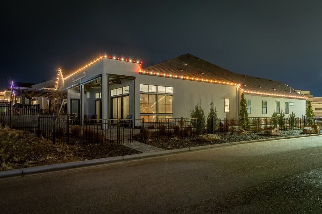 Nighttime Boise home with full Christmas light installation glowing across exterior