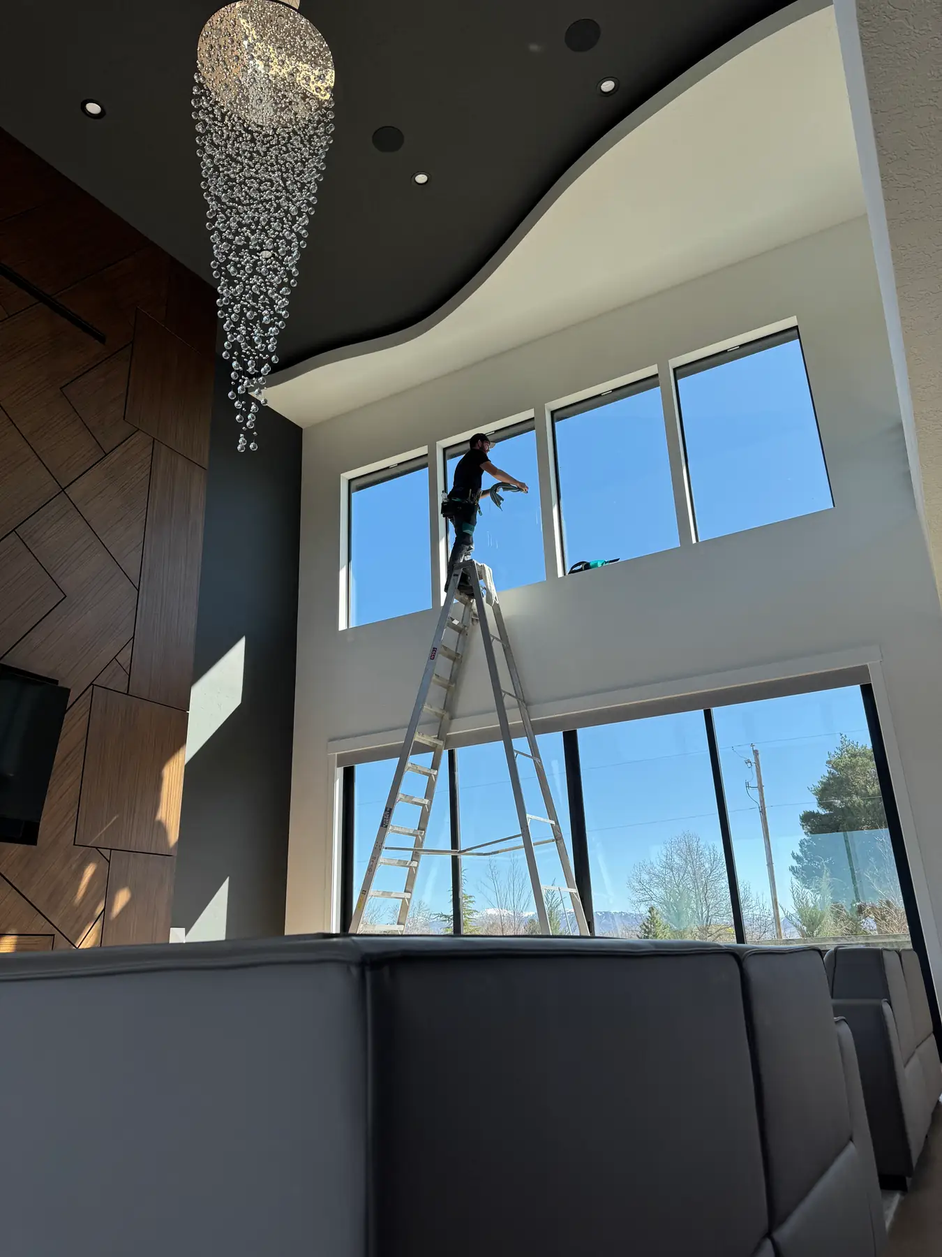 Interior high window cleaning with ladder and chandelier